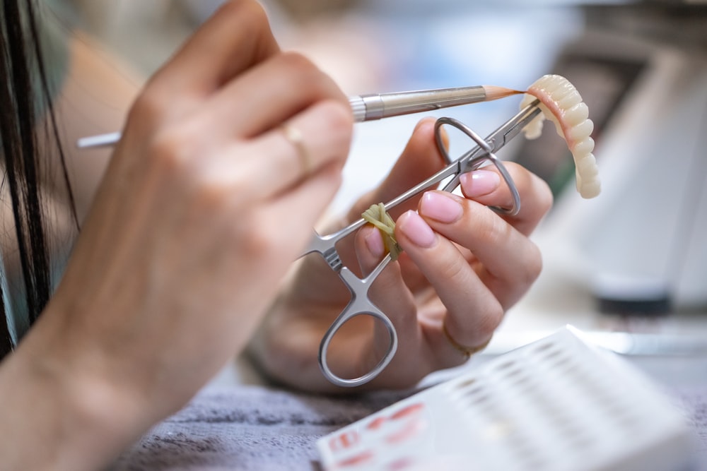 Dental technician finishing a prosthesis at the lab bench